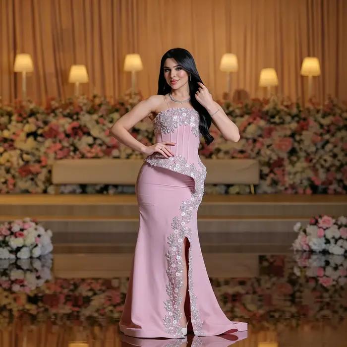 Robe de soirée élégante avec un décolleté droit sans bretelles, une détail asymétrique en peplum orn