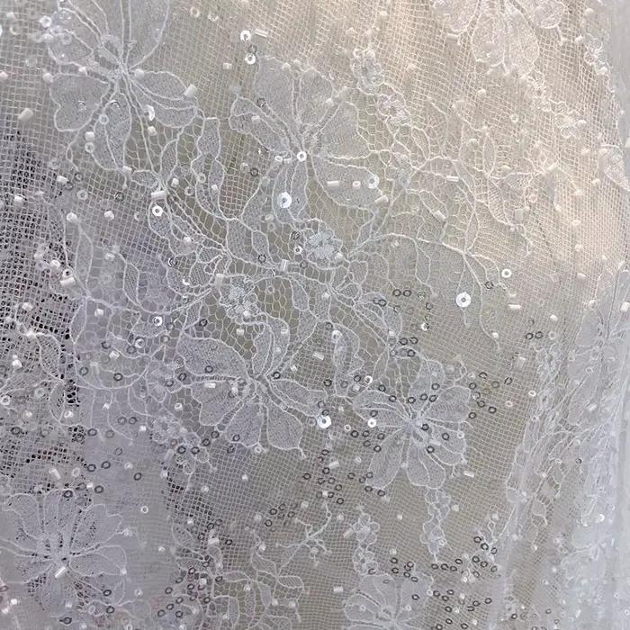 Tissu en dentelle blanche élégant pour robes de mariée et tenues de soirée avec perles et paillettes pour des effets visuels spectaculaires occasions importantes ```