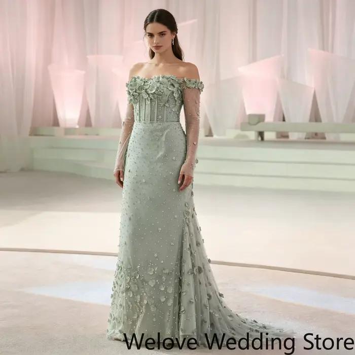 Robe de soirée romantique avec un décolleté épaules dénudées, des manches longues transparentes, des