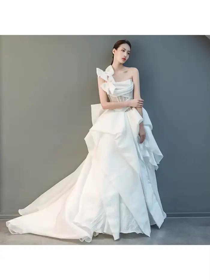 Robe de mariée moderne personnalisée asymétrique en organza coupe trapèze avec grand nœud et volants en cascade pour réception nuptiale et défilé de mode