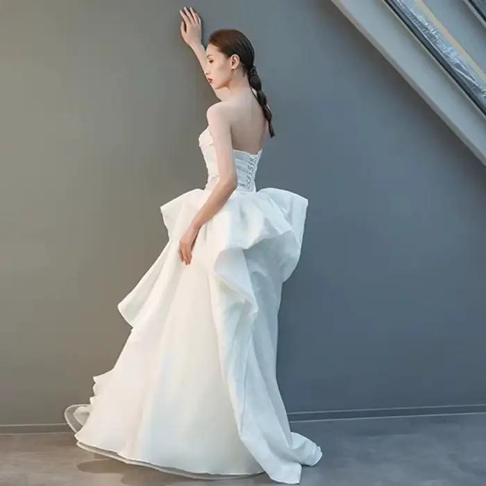 Robe de mariée moderne personnalisée asymétrique en organza coupe trapèze avec grand nœud et volants en cascade pour réception nuptiale et défilé de mode